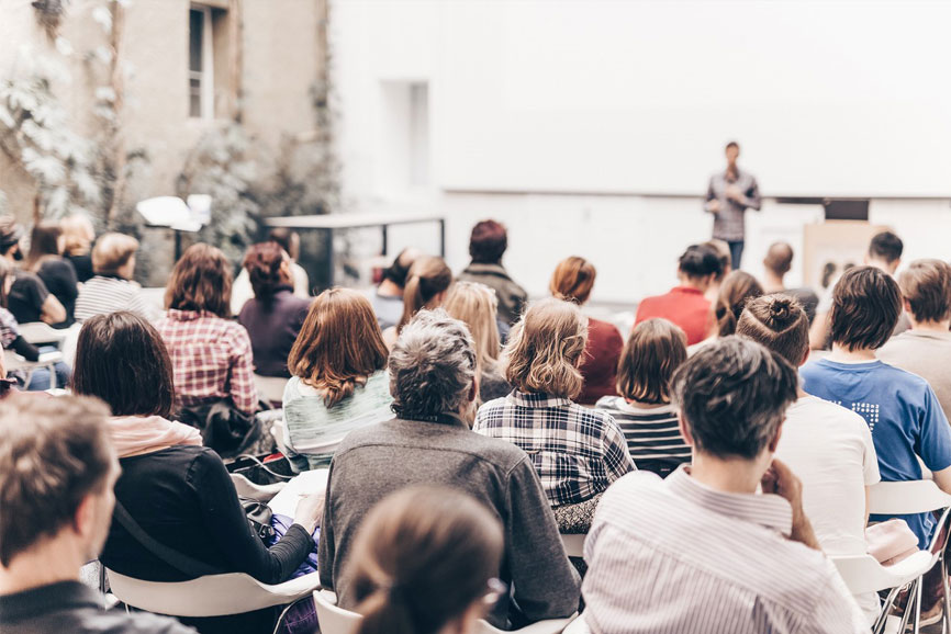 Dies ist ein Beispielbild für das Religionspädagogische Arbeitsforum im März 2025 in Würzburg - es sitzen viele Studenten in einem großen Raum und hören einem Dozenten zu.