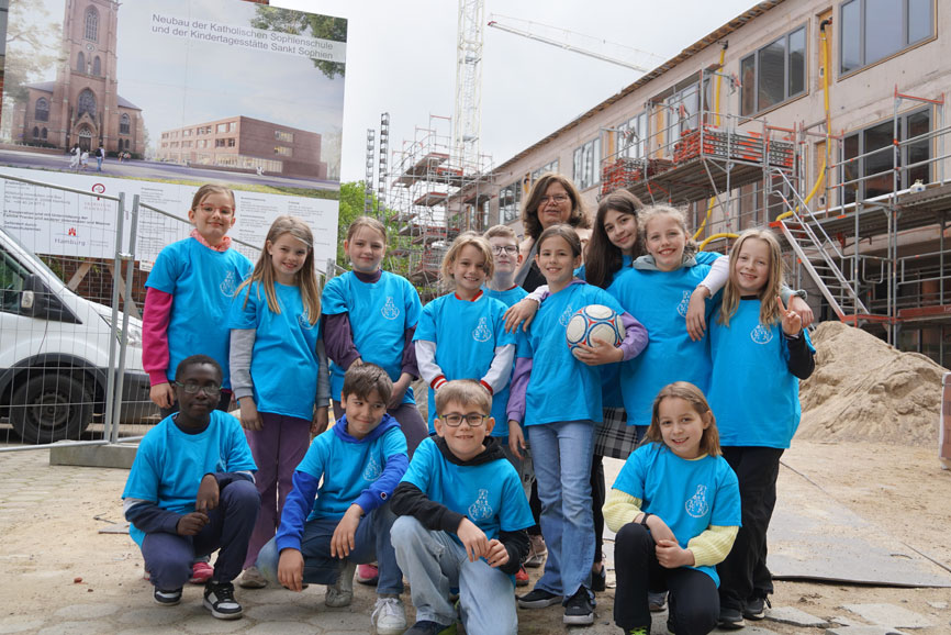 Schülerinnen und Schüler der Katholischen Sophienschule mit ihrer komm. Schulleiterin Beatrice Lipschütz vor dem Neubau in der Elsastraße.