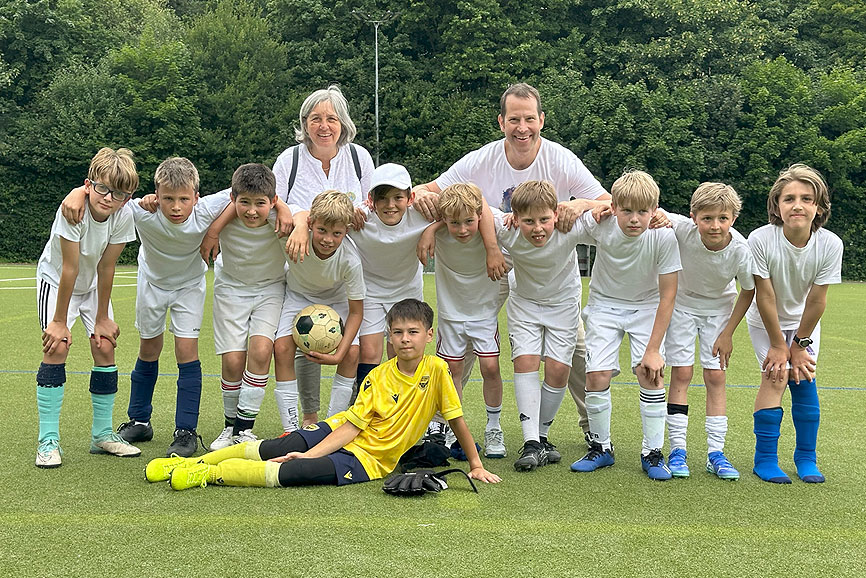 Ansgar-Cup 2025 – Fußballfest der katholischen Schulen Hier zu sehen eine Mannschaft aus einer katholischen Grundschule, die sich alle umarmen und dahinter stehen die Trainerin und der Trainer.