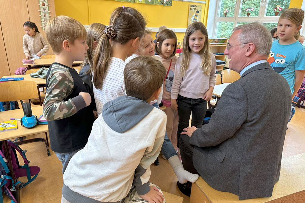 Schulbesuch von Erzbischof Stefan Heße an der Katholischen Schule Farmsen bei Zweitklässlern. Die Kinder sitzen mit dem Bischoff im Kreis.